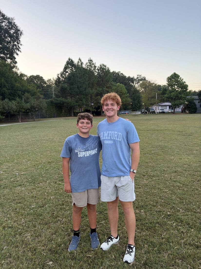 A 55 Athletics coach and a young athlete on the training field