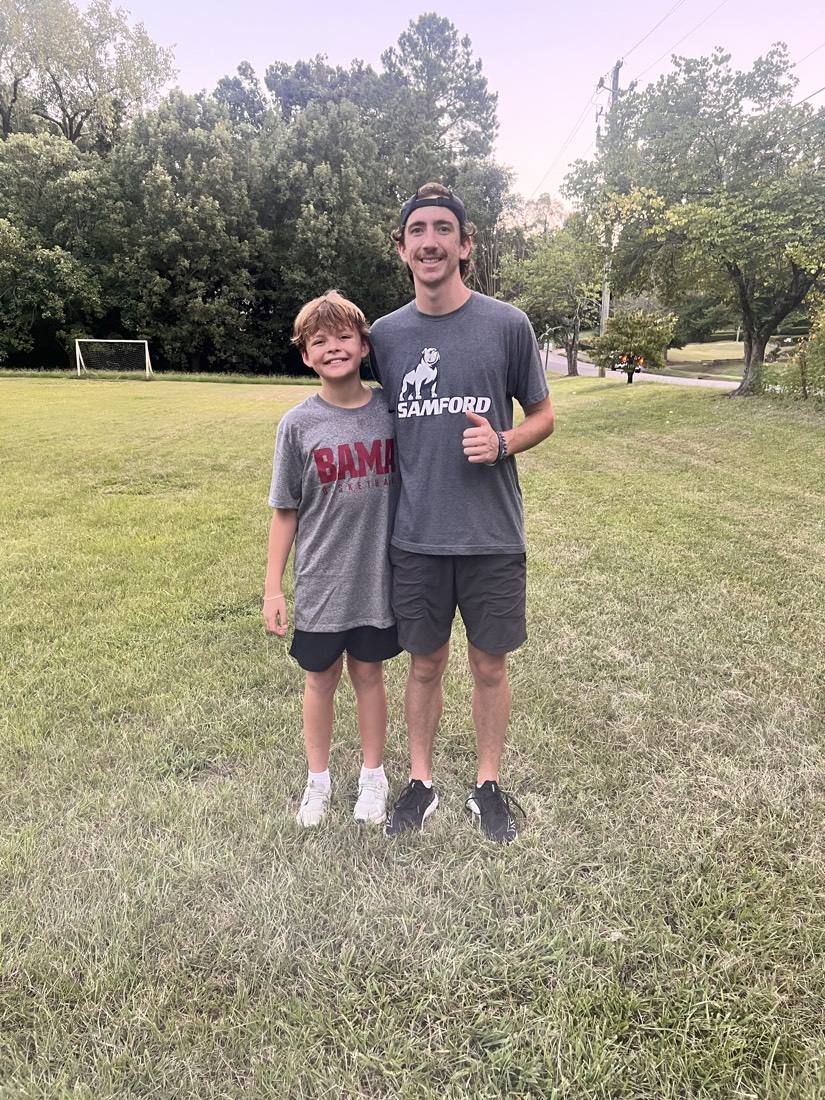 A 55 Athletics coach and a young athlete on the training field